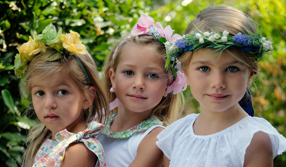 Tre bambine con coroncine di fiori